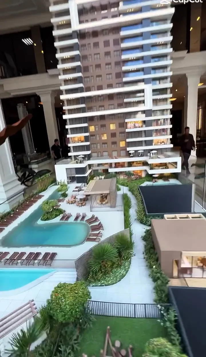 Maquete de área de lazer com piscinas, deck e paisagismo ao pé da torre